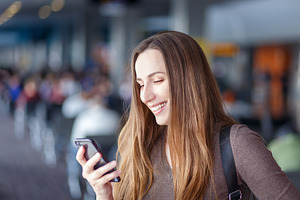 Young smiling woman using smartphone featuring healthy teeth, teeth, and adult
