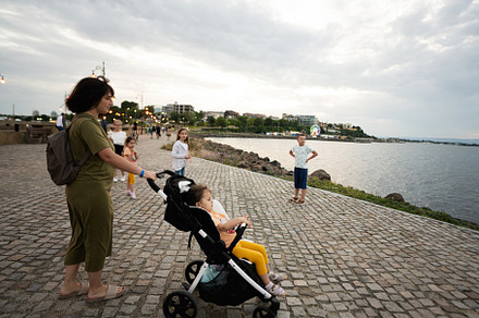 Young mother walking with her baby in stroller on the promenade., a Person Photo by AS photostudio