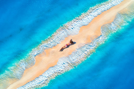 Aerial view of the beautiful young lying woman on the sandy beac, a Holiday Photo by den-belitsky