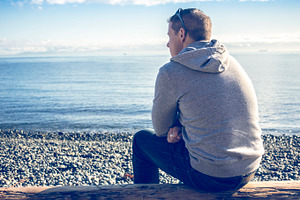 Man sitting looking out at ocean