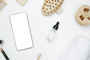Smartphone with blank white screen surrounded by natural skincare and self-care, a Photo by matucha