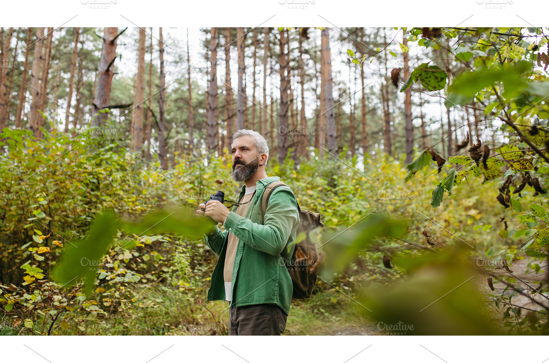Handsome man watching wildlife with, a Sports & Recreation Photo by HalfPoint