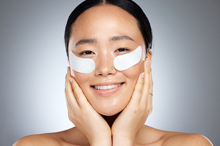 Skincare, beauty and collagen eye mask on woman from Japan for cooling and anti aging skin treatment for youth. Luxury spa facial, natural product for eyes and smile on face of beautiful asian girl., a Photo by Peopleimages.com