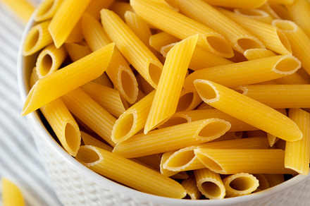 Uncooked Organic Penne Pasta in a Bowl, side view. Close-up., a Food & Drink Photo by LiudmylaChuhunova