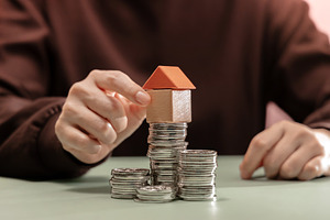 Placing small house model on stacked coins. Saving money, home o, a Photo by salmon.black