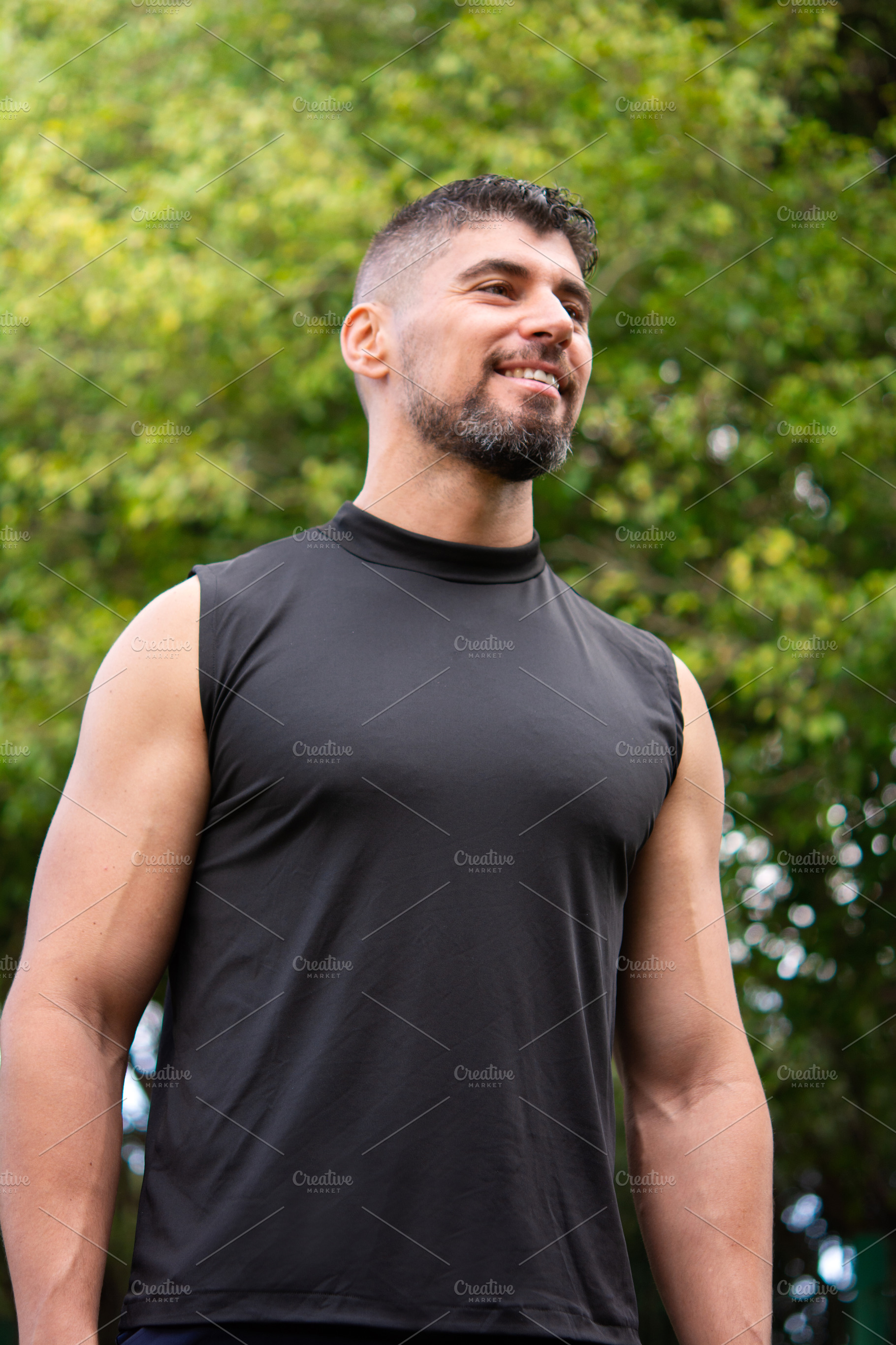 Confident male personal trainer standing outdoors in park looking away, a Sports & Recreation Photo by etorres69