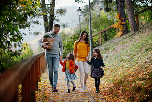 Sisters and parents walking in park, a Person Photo by HalfPoint