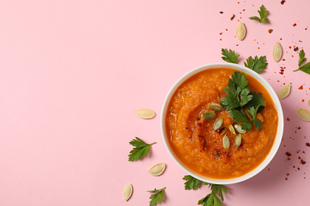 Composition with bowl of pumpkin soup on pink background, top vi, a Food & Drink Photo by AtlasStudio PRO