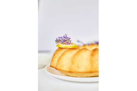 Round lemon cake on white table with, a Food & Drink Photo by IlliaBondarPhotography
