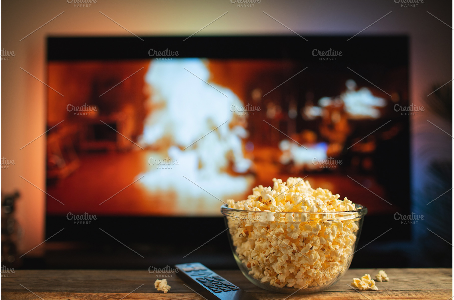 A glass bowl of popcorn and remote, a Technology Photo by Budarinphoto
