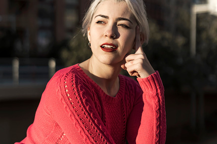 Slim young woman with blonde hair touching face and looking at camera while lea, a Person Photo by 2Design