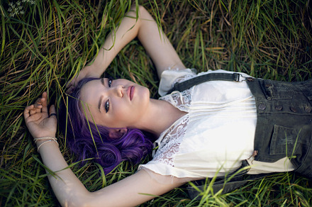 portrait of a teenage girl with purple hair and an earring in her nose lying in, a Person Photo by SaulichPhoto