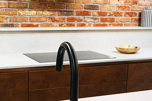 Modern industrial kitchen design featuring a functional black faucet, sink, coo, a Photo by Studio ANNA