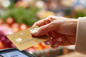 Woman paying with gold credit card a, a Photo by Pixeness Studio