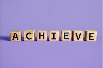 Achieve word on wooden cubes blocks