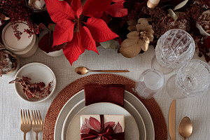 Christmas holiday table setting with festive poinsettias, golden cutlery, and a, a Food & Drink Photo by Anneleven