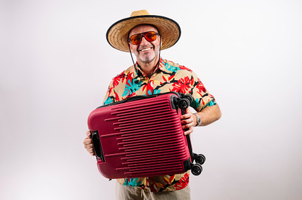 Tourist with red suitcase smiling, a Holiday Photo by karrastock
