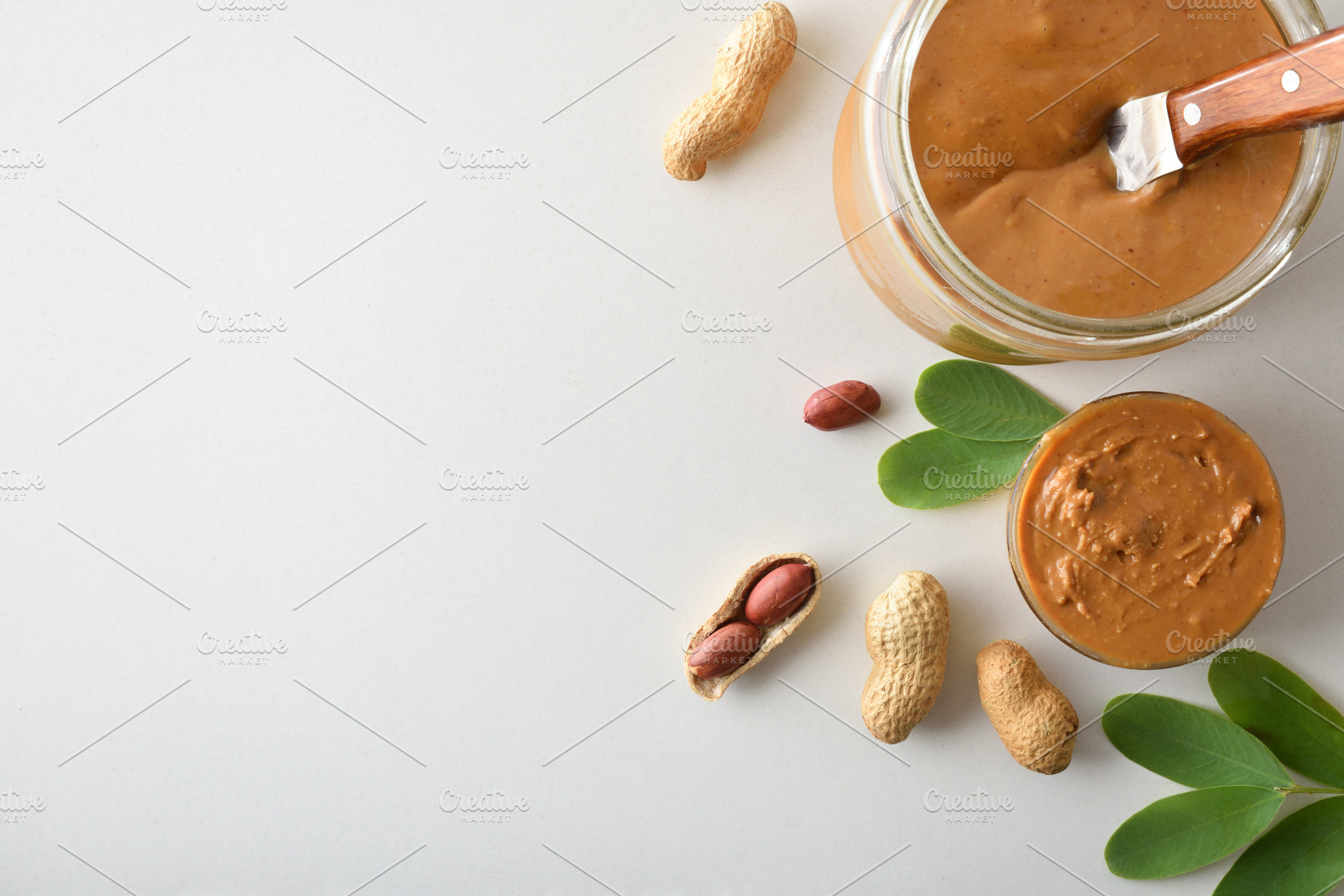 Peanut butter in a jar and peanuts on white background, a Food & Drink Photo by Davizro's Market