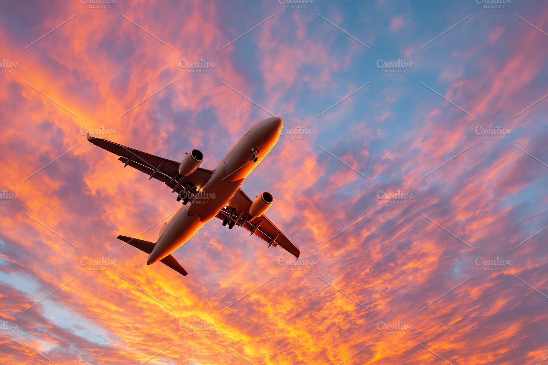 Aircraft flying low against a vibrant sunset sky filled with clouds, a Photo by AlyaAnd