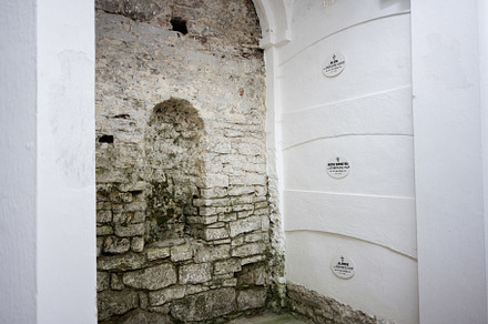 Historic Catholic columbarium with stone walls featuring religious plaques and, a Photo by AS photostudio