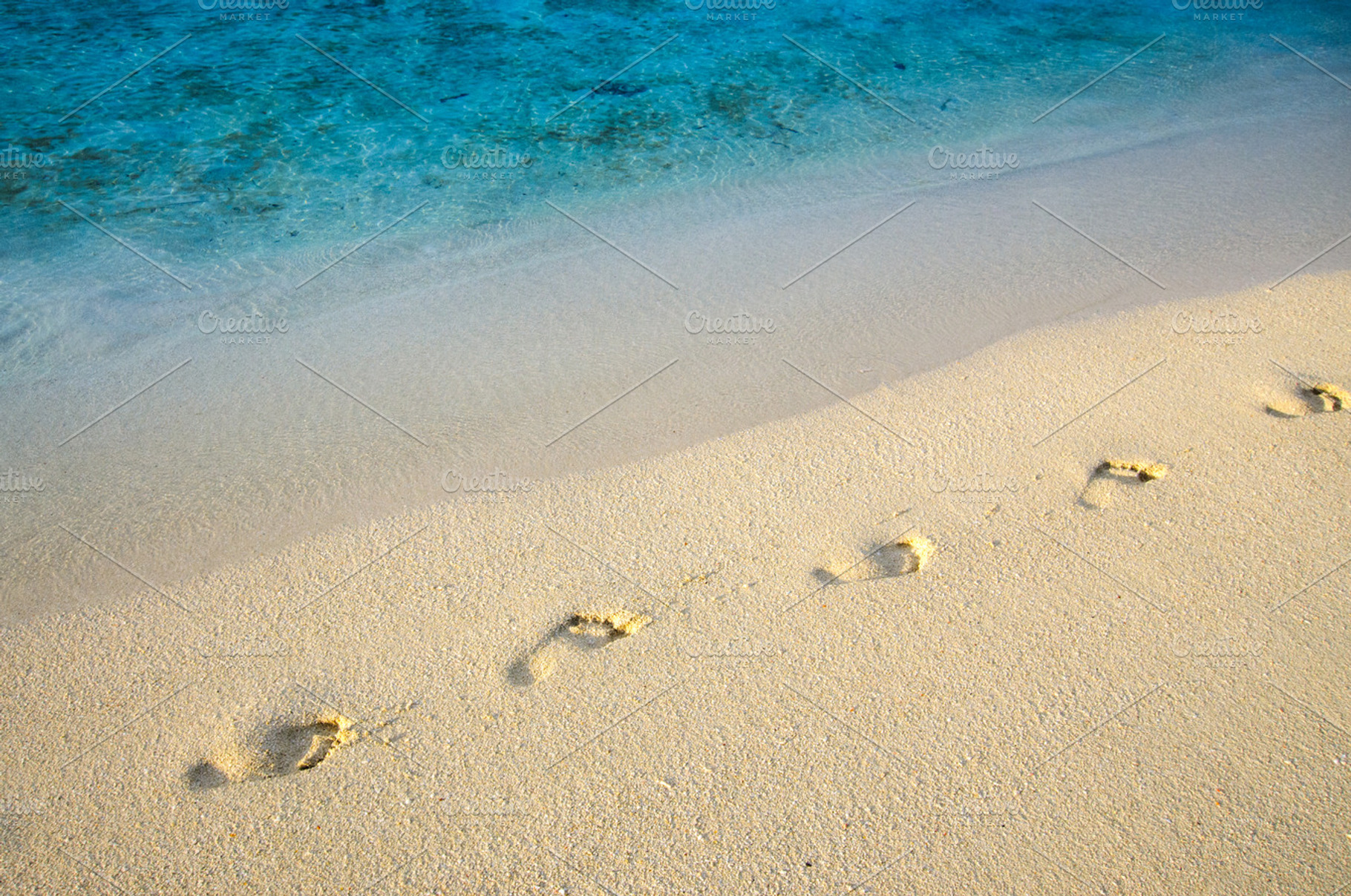 Diagonal footprints on sand beach with sea edge line, a Nature Photo by Edgieus