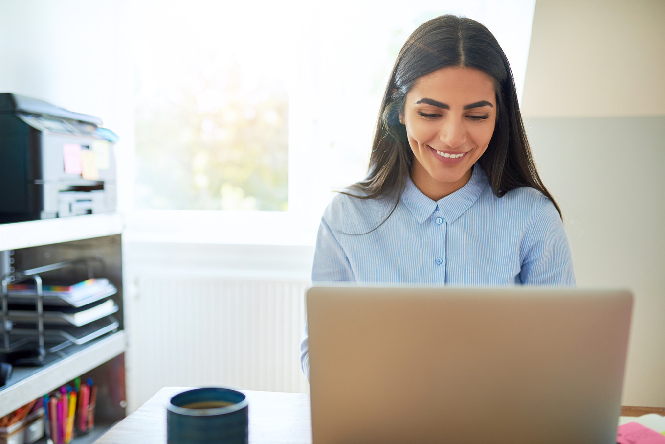 Laughing young Indian woman in front of laptop | Business Images ...