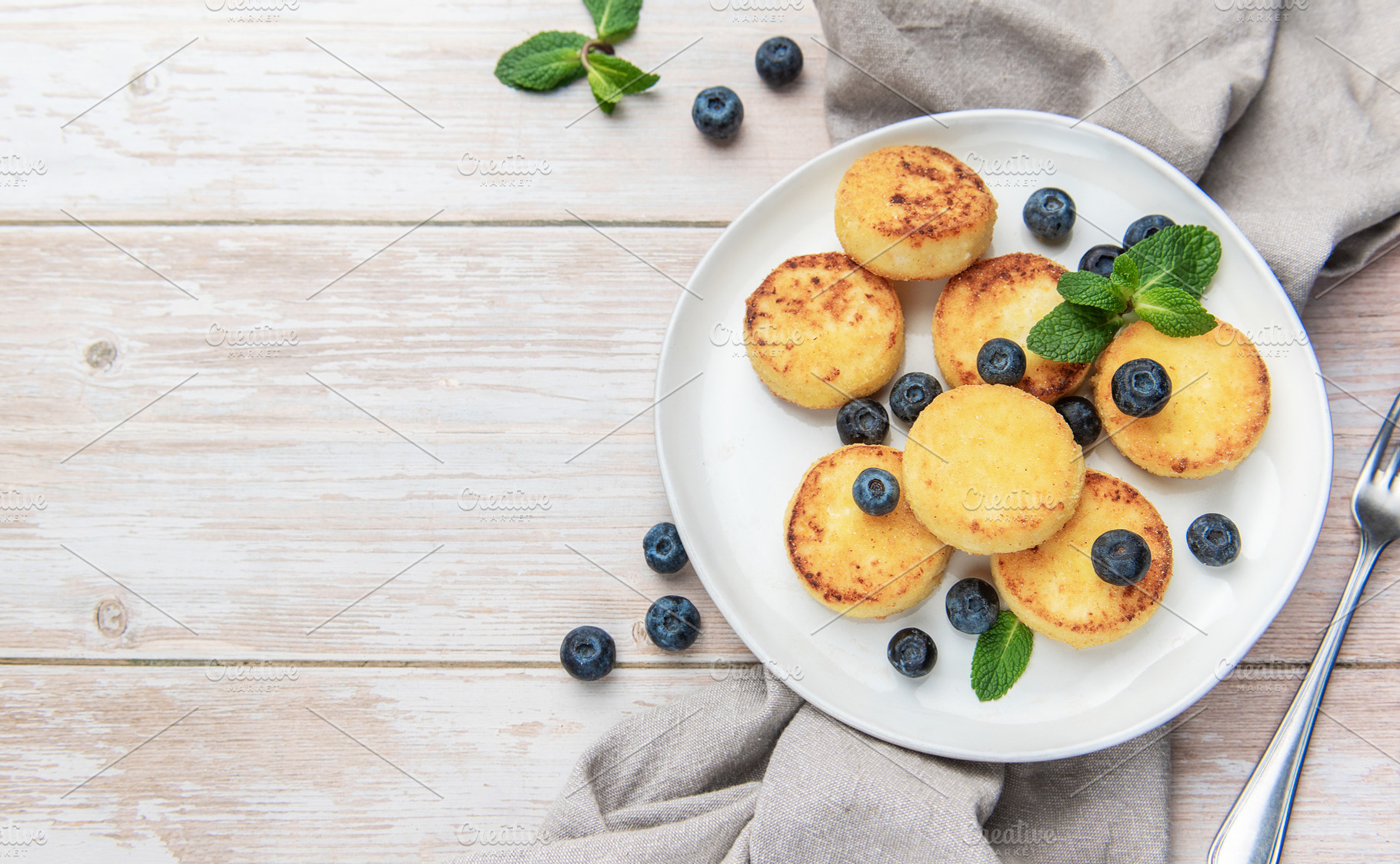 Syrniki cheese pancakes with fresh blueberries and mint, a Food & Drink Photo by Olena Rudo