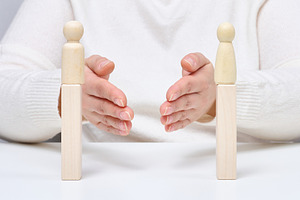 A man uses his hands to bring together two wooden figures on sta, a Person Photo by ndanko