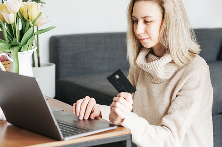 Young woman holding credit card and using laptop., a Person Photo by Olena Rudo