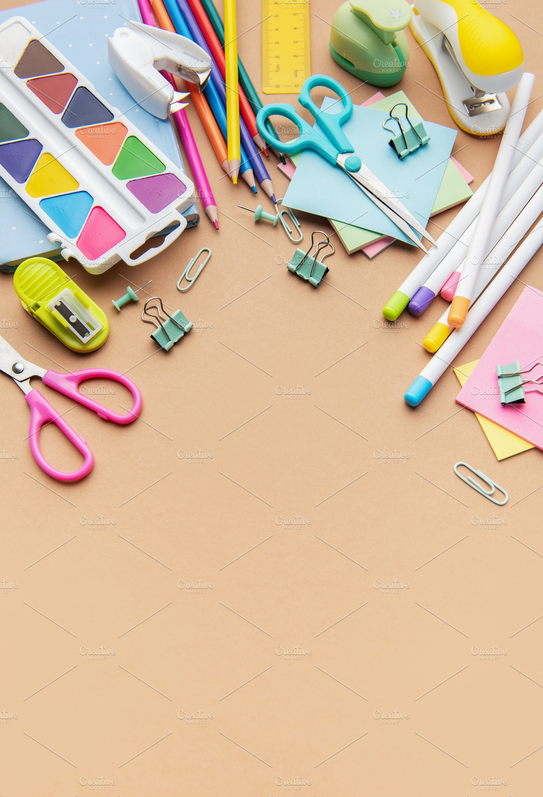 Colorful school and office supplies border on brown background, a School & Education Photo by Olena Rudo