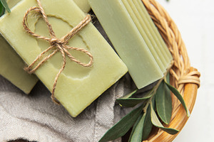 Natural olive soap bars with olive branches in wicker basket on, a Health & Medical Photo by Olena Rudo