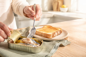Canned sardines being served on toas, a Photo by Dvoevnore photos