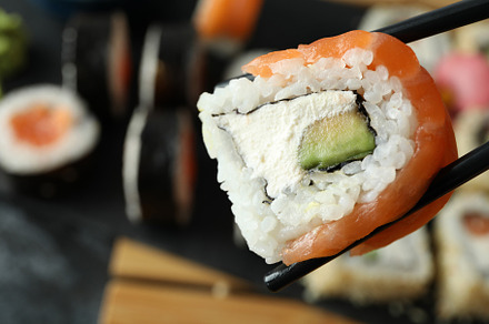 Chopsticks with roll, space for text and close up, a Food & Drink Photo by AtlasStudio