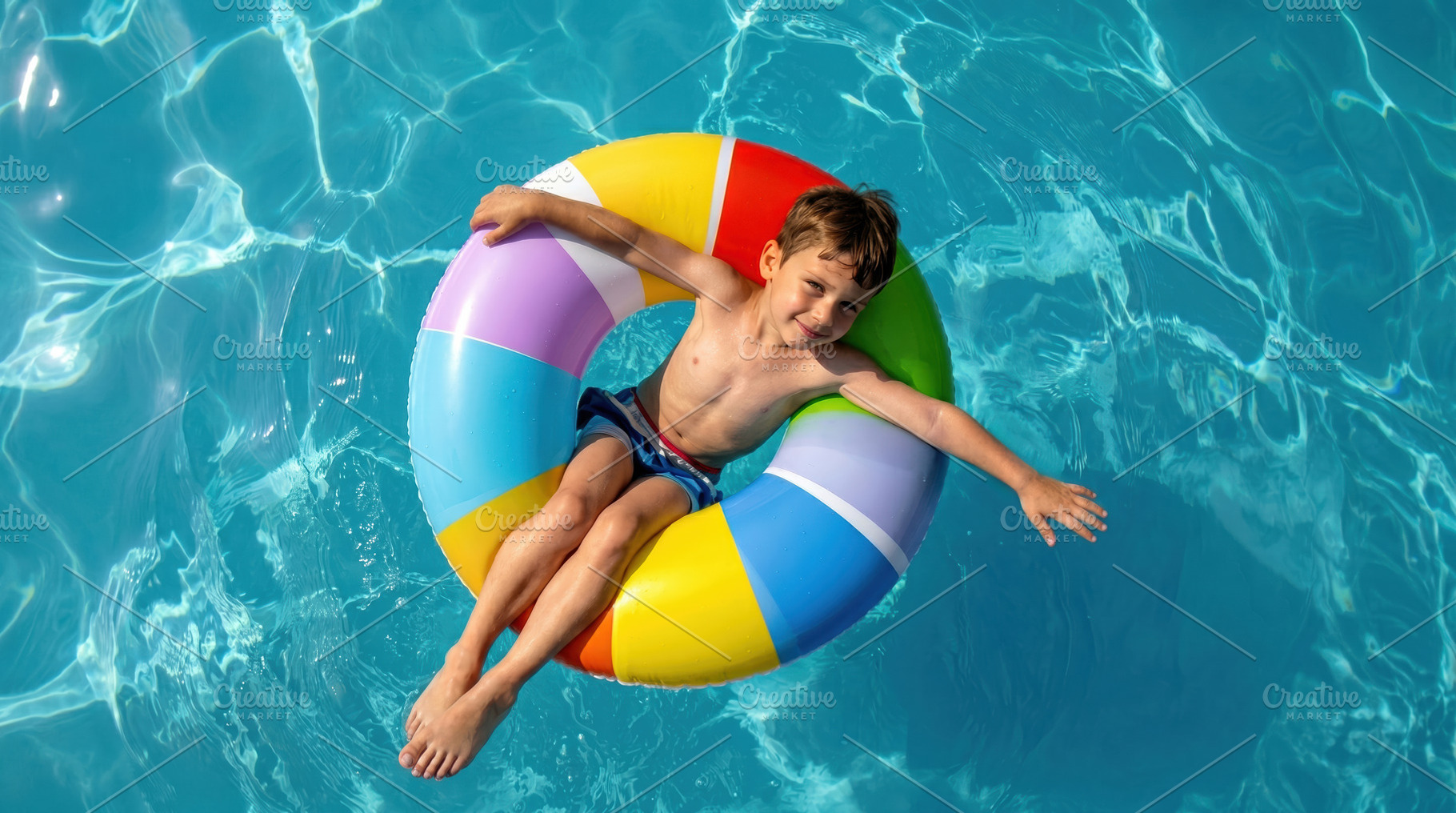 Child floating on colorful pool ring, a Sports & Recreation Photo by Davizro's Market