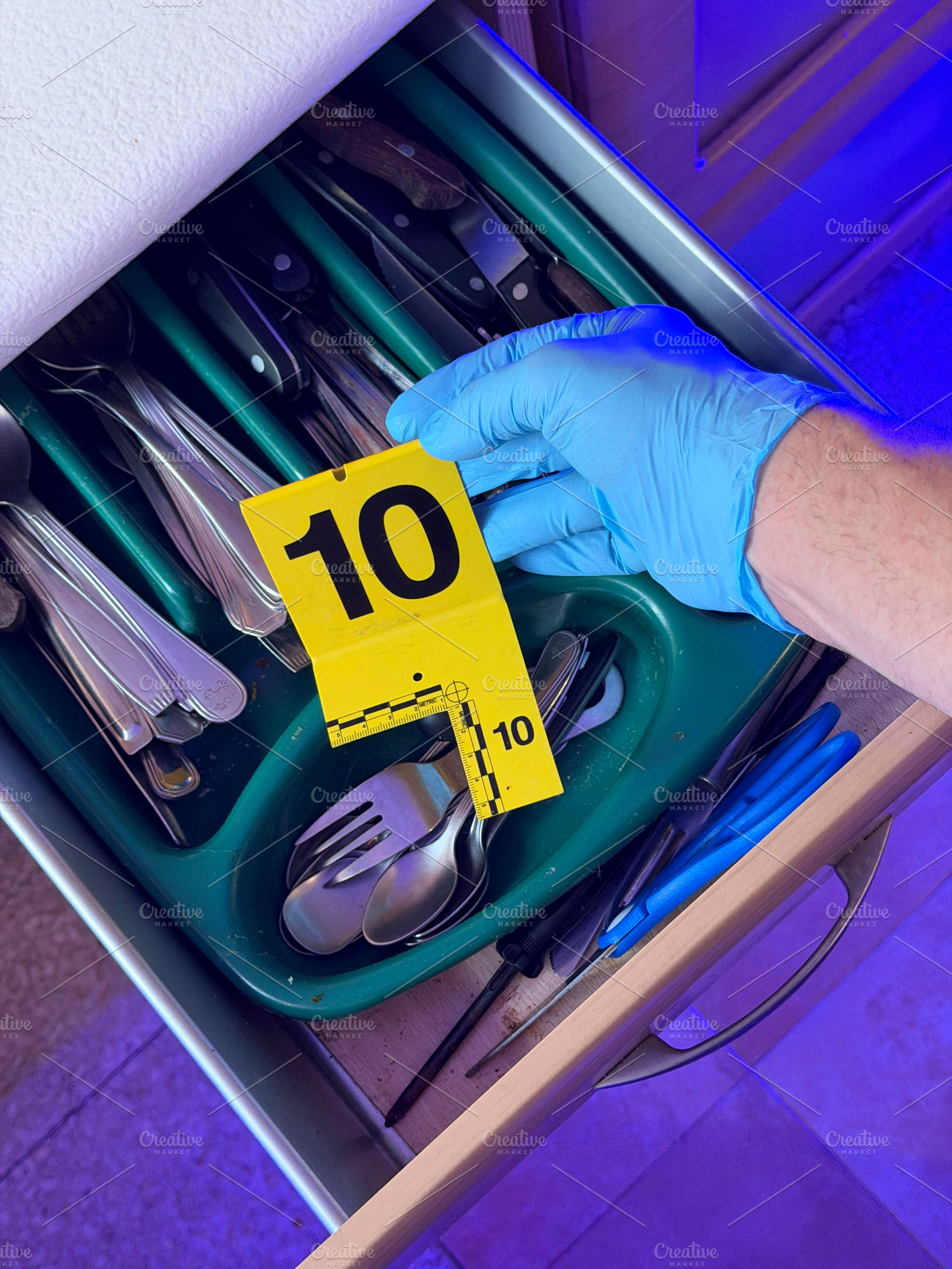 Investigator handling evidence marker at crime scene drawer, an Industrial Photo by karrastock