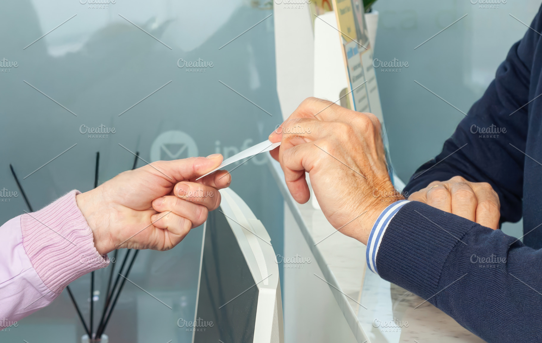 Receptionist handing an appointment reminder card to senior patient in dental c, a Photo by Antonio Gravante Market