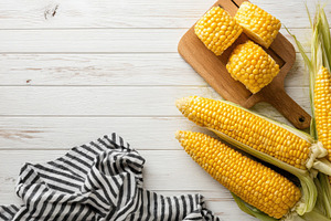 Sweet corn on wooden background rust, a Photo by Pixeness Studio