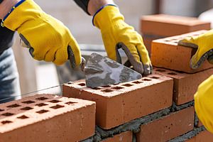 Bricklayer laying bricks on a constr, an Industrial Photo by Stock Shape