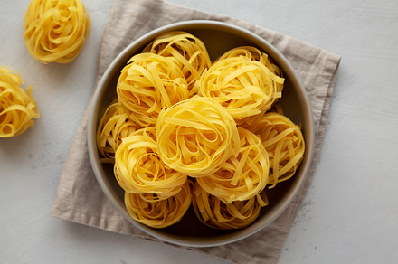 Raw Dry Tagliatelle Pasta in a Bowl, top view. Flat lay, overhea, a Food & Drink Photo by LiudmylaChuhunova