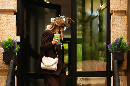 Blonde woman holding coffee cup walk