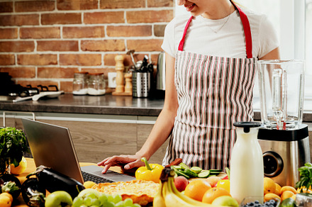Woman using laptop at kitchen, searching recipe, using touchpad at computer, a Food & Drink Photo by Lenor4ik
