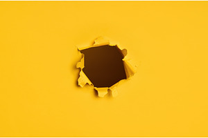Torn hole in yellow paper with dark, a Background Photo by Gladkov photography