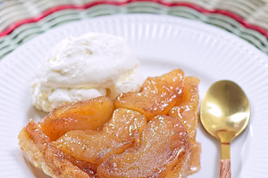 Slice of delicious apple tarte tatin with scoop of whipped cream, french upside, a Food & Drink Photo by iuliia_n