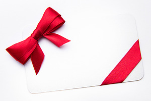 White card with red ribbon bow for celebration, a Holiday Photo by Olena Rudo