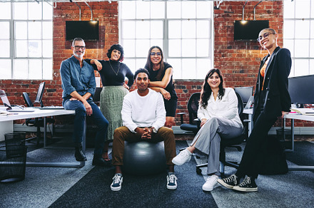 Happy team of businesspeople smiling in a modern office, a Person Photo by Jacob Lund