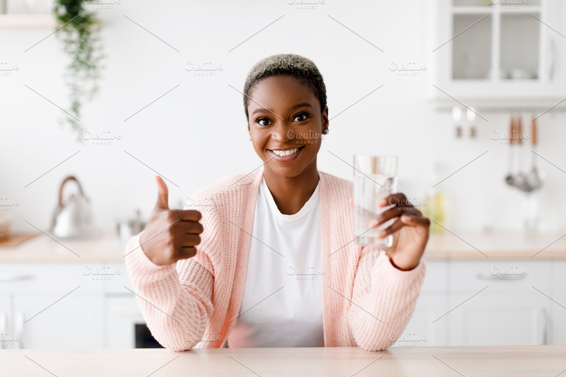 Glad smiling young pretty black woman with perfect skin holds glass with clean, a Person Photo by Prostock-Studio