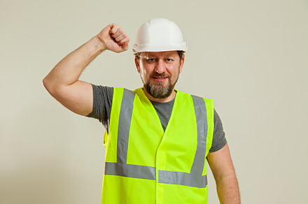 worker in a vest and white helmet, a Person Photo by Photostock