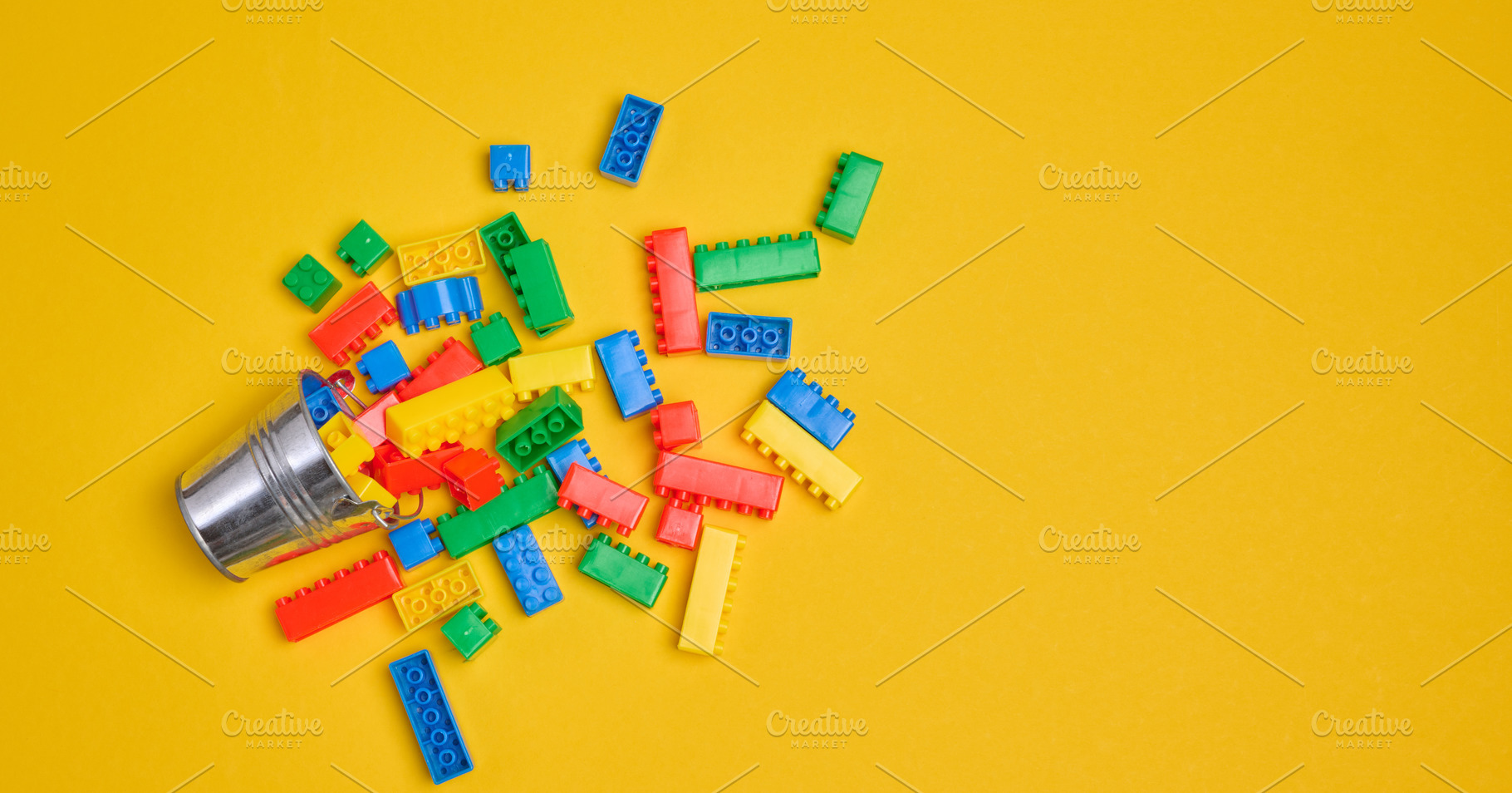 Vibrant colorful building bricks spilling from a silver metal bu, a School & Education Photo by ndanko