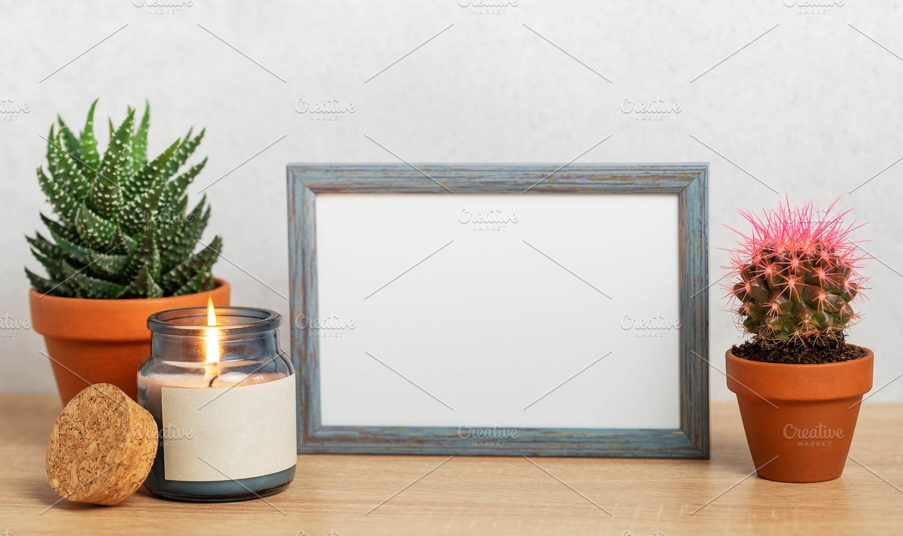 Empty frame, burning candle and succulents creating cozy home at, a Background Photo by Olena Rudo