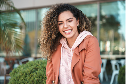 Latin woman smiling while standing, a Person Photo by Mego-studio